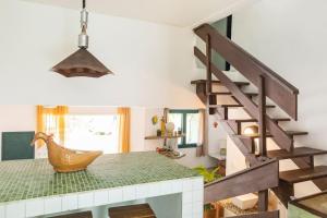 巴拉尤娜Delba Costa Smeralda - Barra do Una的客房设有楼梯和带椅子的桌子。