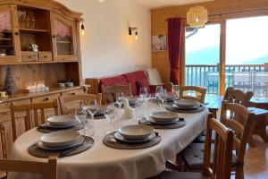 维拉尔叙尔多龙La Perle des Alpes C10 Apart.4* #Yolo Alp Home的用餐室配有带盘子和酒杯的桌子