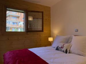 维拉尔叙尔多龙La Perle des Alpes C10 Apart.4* #Yolo Alp Home的卧室配有白色的床和窗户