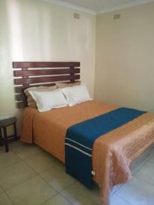 哈拉雷2 bed guesthouse in Mabelreign - 2012的一间卧室配有一张大床和木制床头板