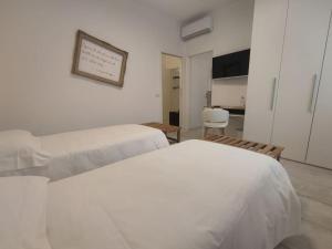奥里奥阿塞里奥fuORIOrbita的一间白色卧室,配有两张床和厨房