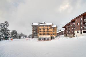 La Plagne TarentaiseChalet Hôtel Turquoise的大楼前的雪地停车场