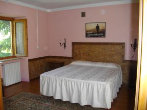 卡内利马提内拉农家乐的卧室配有一张床,墙上挂着一幅画