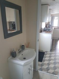 诺丁汉Lovely 2-Bed Chalet at Robinhood Retreat Free park的白色的浴室设有水槽和镜子