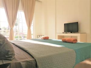 蓬塔卡纳Art Villa的一间卧室配有一张带两个橙色枕头的床