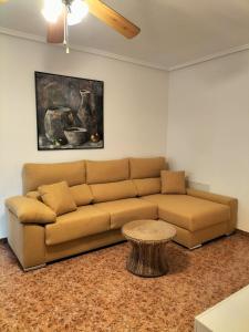 格兰阿利坎特Aitana Apartment的客厅配有棕色沙发和桌子