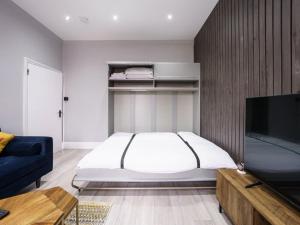 伦敦Modern apartment near Wembley Stadium的一间卧室配有一张床和一台平面电视
