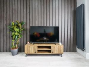 伦敦Modern apartment near Wembley Stadium的木质娱乐中心顶部的平面电视