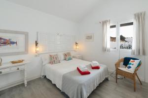 埃尔戈尔福Casa Rural Caleton del Golfo的白色卧室配有床和椅子