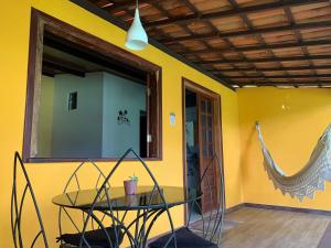 伦索伊斯Pousada e Camping Lumiar的黄色墙壁的房间里一张玻璃桌
