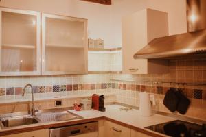 维罗纳Casa Sgarzarie exclusive apartment的厨房配有白色橱柜和水槽