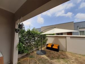 阿克拉Lovely 2-Bed House in Accra East legon hills的天井下配有遮阳伞和2把椅子