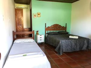 UnaAláfia Comandatuba的绿墙客房内的两张床