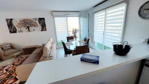 塞尔吉Cosy Home 1, Cergy Le Haut, 6 personnes, 3 min gare, 30 min Paris, parking privé的客厅配有桌子和沙发