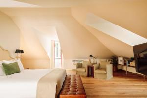 里斯本Hotel das Amoreiras - Small Luxury Hotels of the World的一间卧室配有床、沙发和楼梯。