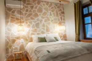 约阿尼纳locanta的一间卧室设有石墙和床