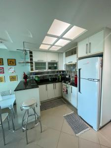 安格拉杜斯雷斯Apartamento Porto Real Resort (11.1 402) com vista panorâmica的厨房配有冰箱和桌椅