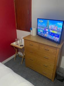 普里茅斯Southway Double Room near Derriford的一间卧室,配有带桌子的梳妆台和电视机