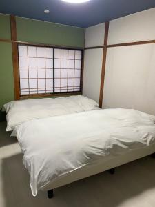 弘前市guest house goose - Vacation STAY 23621v的带2扇窗户的客房内的2张单人床