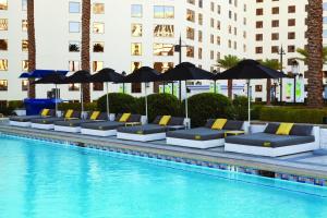 拉斯维加斯好莱坞之星球赌场度假酒店的游泳池旁的一排躺椅和遮阳伞