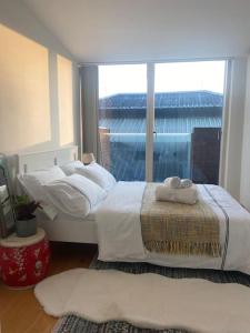 伦敦Spitalfields Market Penthouse Flat with balcony的带大窗户的客房内的两张床