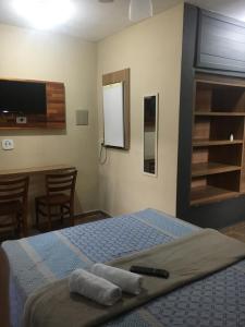 卡拉瓜塔图巴Pousada Morada Dusanjos的一间卧室配有一张床,上面有两条毛巾