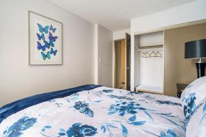 卡尔加里Entire Condo Downtown, near BMO & Stampede, free Parking, 1,5 hrs to Banff的一间卧室配有一张带蓝白色毯子的床