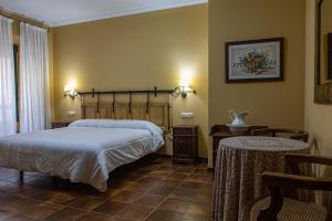 Perales del PuertoDON JULIO的一间卧室配有一张床、一张桌子和两把椅子