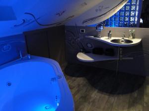 罗马爵士风格度假屋的蓝色的浴室设有浴缸和水槽