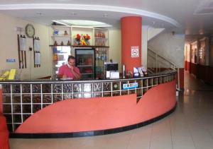 贝伦Hotel Paraiso Belém的站在商店柜台上的人