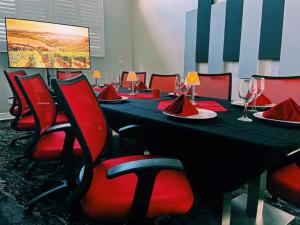 蓬塔戈尔达Wyvern Hotel, Ascend Hotel Collection的一间会议室,配有长桌子和红色椅子