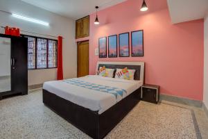 布巴内什瓦尔OYO Home Jaam's Home Stay的一间卧室设有一张大床和粉红色的墙壁
