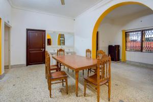 布巴内什瓦尔OYO Home Jaam's Home Stay的一间带木桌和椅子的用餐室