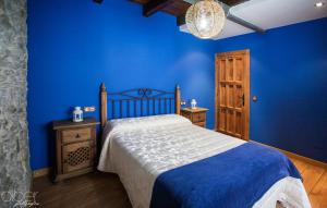 Caboalles de Abajo卡萨农村邦戈旅馆的蓝色的卧室,配有床和蓝色的墙壁