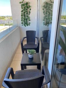 奇廉Departamentos Apart Hotel Chillán Center SPA的阳台配有两把椅子和一张桌子,种植了植物