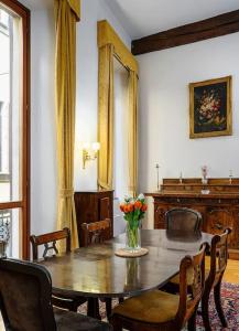 米兰Piazza DUOMO - Antico Appartamento dell'800的用餐室配有带鲜花的木桌