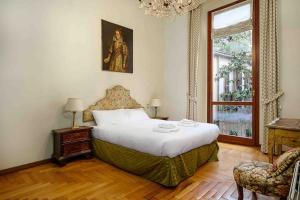 米兰Piazza DUOMO - Antico Appartamento dell'800的一间卧室设有一张大床和一个窗户。