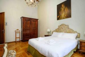 米兰Piazza DUOMO - Antico Appartamento dell'800的卧室配有一张床,墙上挂有绘画作品
