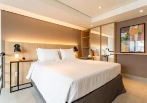 圣保罗Cozzy Suites Paraíso Hotel的卧室配有一张白色大床