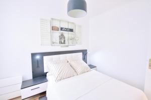 巴黎Paris La Villette - Charming Apartment 2 rooms的一间卧室配有一张白色的床和黑色床头板