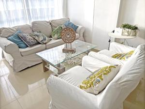 圣安德烈斯Espectacular Apartamento con Vista al Mar的客厅配有2张白色沙发和玻璃桌