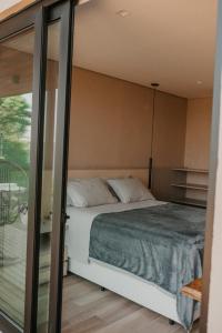 南卡希亚斯Casas na montanha - Villa Montegrappa的一间卧室设有一张床和玻璃墙