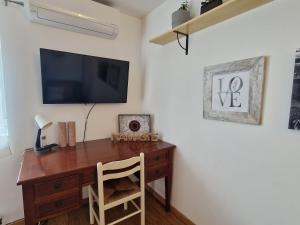 科维良Moradia T2 em bairro pitoresco da Covilhã的客房设有一张木桌,墙上配有电视
