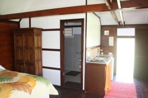 乌图罗阿赖阿特阿岛机场简易别墅度假屋的一间卧室配有一张床,浴室设有水槽