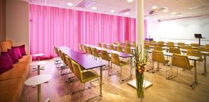 斯德哥尔摩贝斯特韦斯特时代酒店的配有桌椅和粉红色窗帘的房间