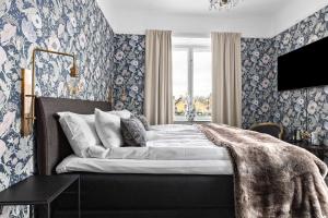 诺拉Nora Stadshotell, Sure Hotel Collection by Best Western的一间卧室配有一张蓝色花卉壁纸床