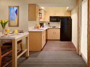 莫尔文Avia Residences on Lincoln - Extended Stay的厨房配有桌子和黑冰箱。