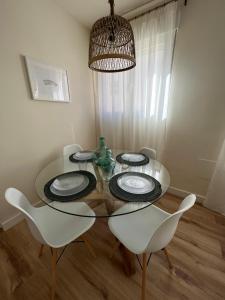 科尔多瓦Apartamento Córboba Centro的一间设有玻璃桌和白色椅子的用餐室