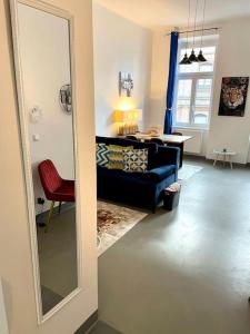维也纳Sehr Zentrale Wohnung-Loftstyle-的客厅配有镜子和蓝色沙发