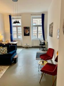 维也纳Sehr Zentrale Wohnung-Loftstyle-的客厅配有红色椅子和蓝色沙发
